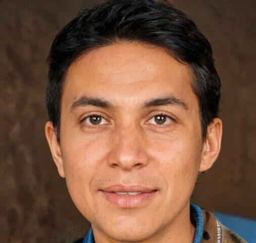Foto de rostro de un hombre con cabello oscuro y ojos marrones.