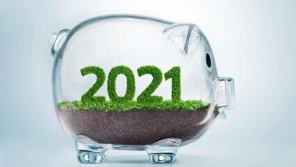 Alcancía de cristal con el año 2021 en hierba. Invirtiendo en el futuro.