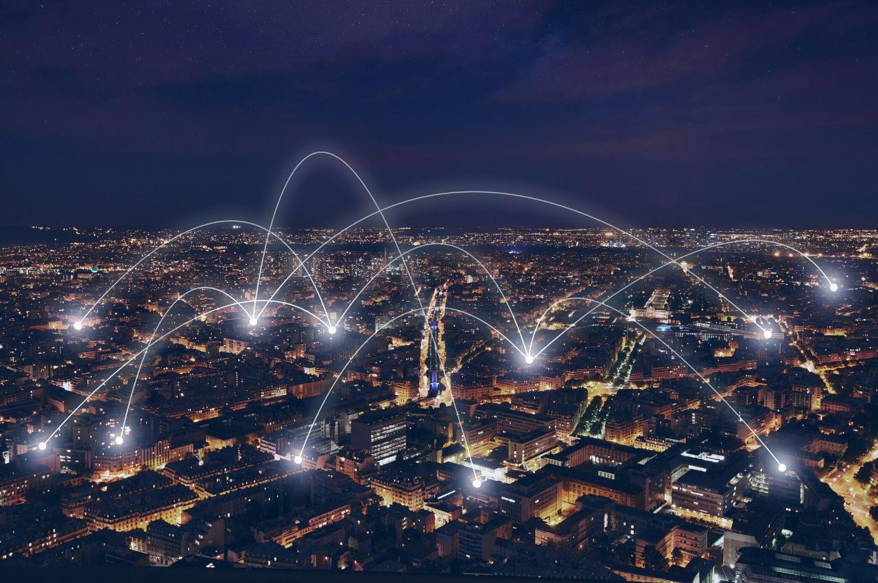 Horizonte de una ciudad nocturna con conexiones de red brillantes que ilustran un ecosistema empresarial.
