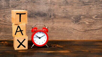 Bloques de madera con la palabra "TAX" junto a un despertador rojo. Fecha límite para el impuesto a las ganancias de la bolsa peruana.