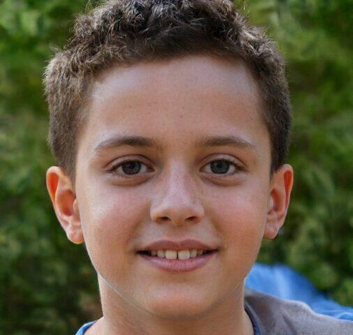Retrato de un niño sonriente con cabello castaño corto.